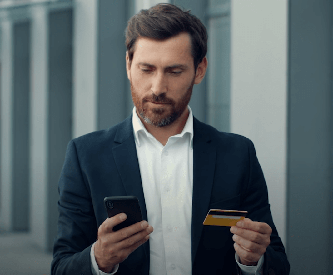 Business person using phone and credit card